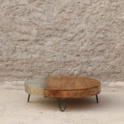 mesa de centro redonda de madera maciza y patas de fierro. Tiene un detalle de bronce tallado. Estilo moderno y minimalista